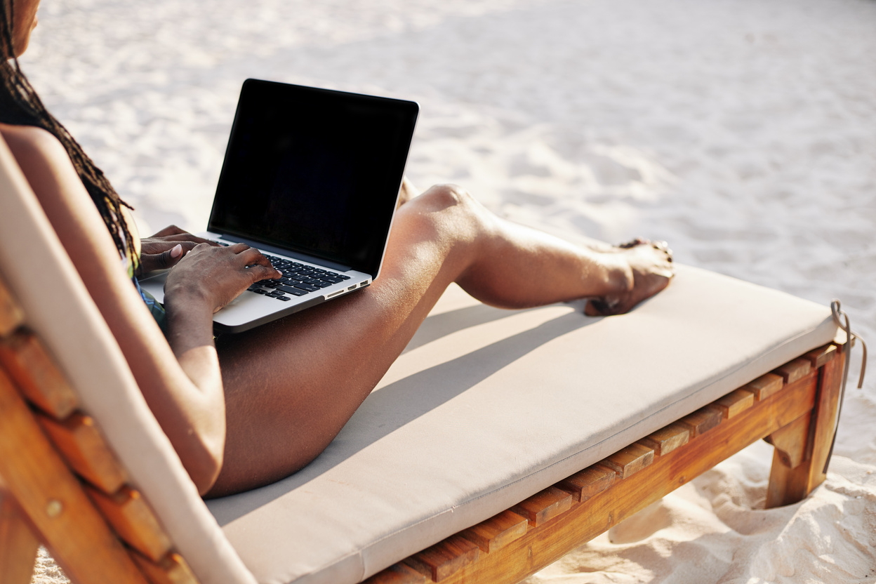 Woman Working on Laptop on Beach